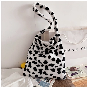 Detail shot of the plush faux fur texture and cow print pattern on a large tote bag