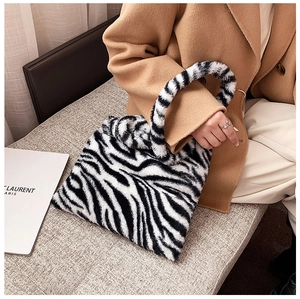 Detail of soft zebra print plush tote bag with furry texture and matching handles