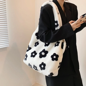 Detailed texture of white plush tote bag with black flower pattern and thick strap