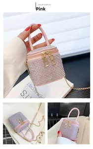 Detail of pink rhinestone handbag featuring double zippers and a golden metal chain