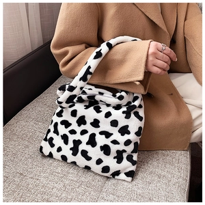 Detailed view of plush cow print tote bag with soft faux fur texture and sturdy handle