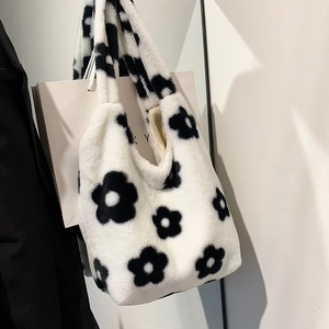 Detailed macro view showing the soft plush fabric and black floral pattern of the tote bag