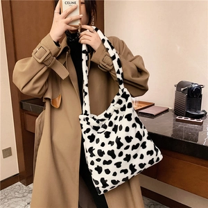 Detail of soft faux fur tote bag with black and white cow print and wide shoulder strap