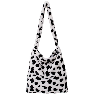 Macro detail of the soft faux fur texture and black-white cow print on the tote bag