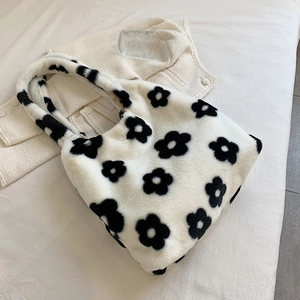 Detail view of plush tote bag showing soft fuzzy texture and black floral patterns