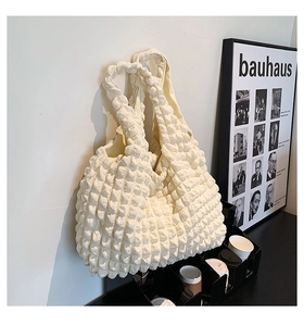 Close-up of white bubble texture fabric on a modern minimalist shoulder bag with strap