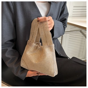 Close-up of champagne gold rhinestone evening bag paired with a gray suit blazer