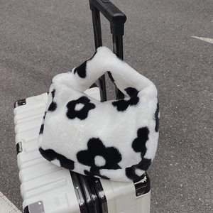 Chic faux fur shoulder bag with black and white flower pattern on a white suitcase