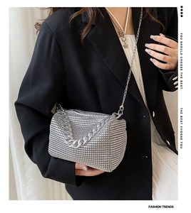 Detailed view of silver rhinestone handbag with chunky metal chain and long shoulder strap