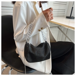 Close-up of black rhinestone handbag with thick silver chain handle and zipper closure