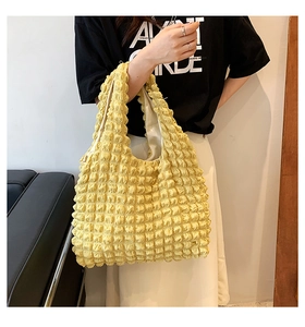 Detail of light yellow bubble fabric tote bag showing soft texture and shoulder fit
