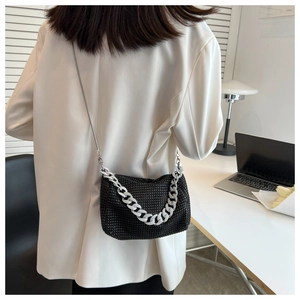 Close-up of black rhinestone handbag with thick silver chain on a shoulder model