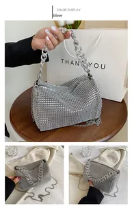Detail of silver rhinestone handbag with chunky acrylic chain and metallic shoulder strap