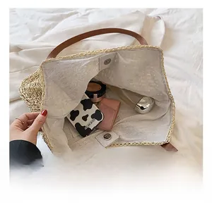 Top view showing internal capacity of straw tote bag with brown leather strap