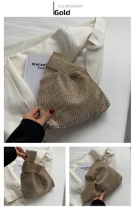 Detail view of a luxury gold knot bag with sparkling rhinestones and a unique handle design
