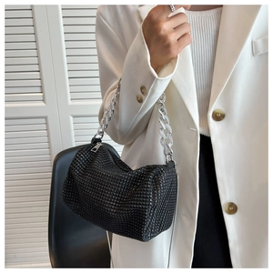 Detail of black rhinestone handbag with chunky silver chain handle on model