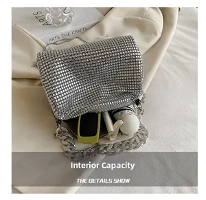 Detail view of silver rhinestone crossbody bag interior showing storage for phone and lipstick