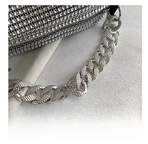 Close-up of polished silver metal curb chain and shimmering rhinestone bag surface