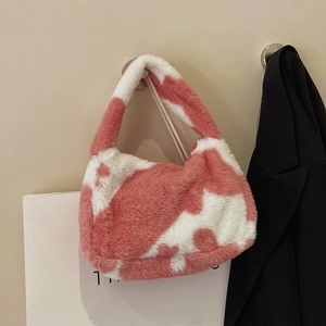 Detailed view of the soft pink and white cow print plush texture on the faux fur shoulder bag