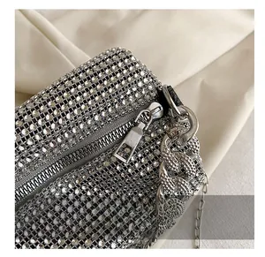 Detail showing smooth zipper closure and shiny silver rhinestones on the handbag