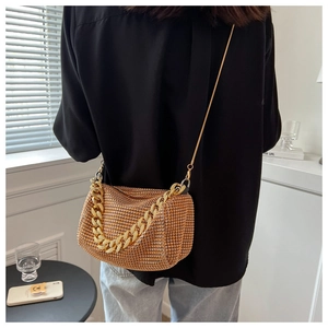 Detail of champagne gold rhinestone handbag with chunky metal chain and long shoulder strap
