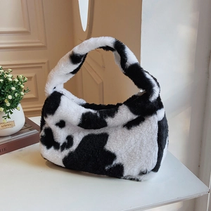 Close-up of cow print plush crescent bag with soft faux fur texture and zipper detail