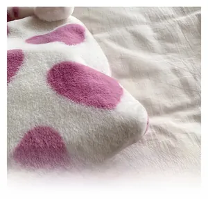 Close-up of soft purple floral pattern plush fabric on a shoulder bag with fluffy texture