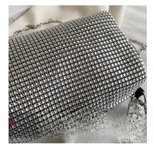 Close-up of sparkling silver rhinestone handbag with chunky metal chain strap and luxury texture