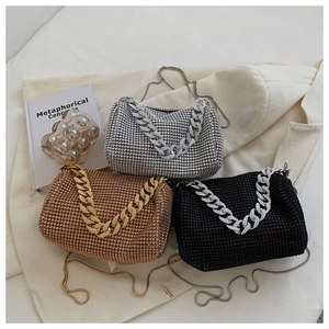 Detailed close-up of sparkling rhinestone clutch bags in silver, gold, and black with chain