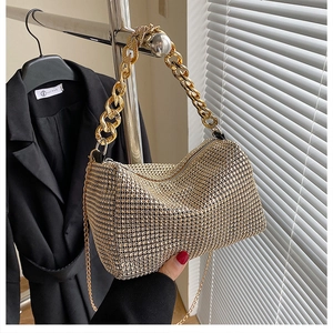 Detail of gold rhinestone handbag with chunky chain handle and sparkly textured surface