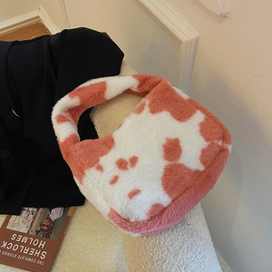 Detailed texture view of soft pink and white cow print plush faux fur shoulder bag