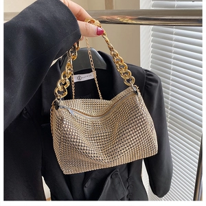 Detailed close-up of golden rhinestone handbag with metallic chain handle for women