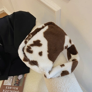 Detail of cow print plush shoulder bag with faux fur texture and top zipper closure