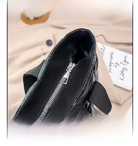 Detail of smooth metal zipper and glossy quilted fabric on black puffer tote bag