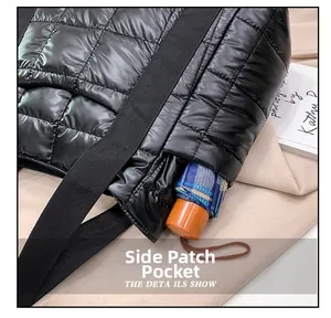 Detail showing the side pocket of black quilted tote bag holding a folding umbrella