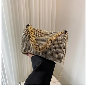 Close-up of luxury champagne gold rhinestone handbag with thick gold chain handle
