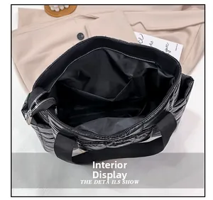 Interior view of the black quilted tote bag showing lining, side pocket, and metal zipper