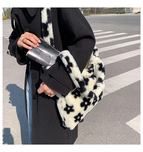 Close-up of soft plush black and white flower pattern shoulder bag with faux fur texture