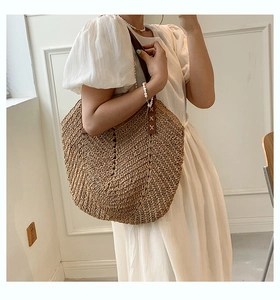 Detail of V-shaped straw weave pattern and reinforced brown leather strap stitching