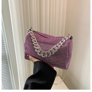 Close-up of pink-purple rhinestone handbag with silver metal chain straps and zip closure