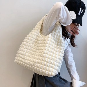 Minimalist white pleated cloud shoulder bag with popcorn texture shown on model