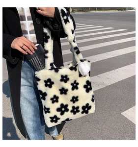 Detail of soft plush tote bag with black flower pattern and white heart charm