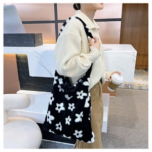 Detail of plush tote bag with flower pattern shown on shoulder for capacity and texture