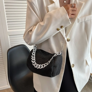 Fashionable black rhinestone crossbody bag with silver chain strap shown on a model