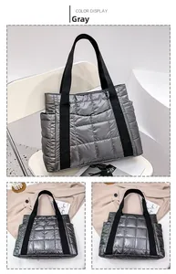 Close-up of a silver quilted tote bag showing padded fabric and black handles