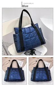 Detailed view of dark blue quilted puffer tote bag with glossy finish and strap detail