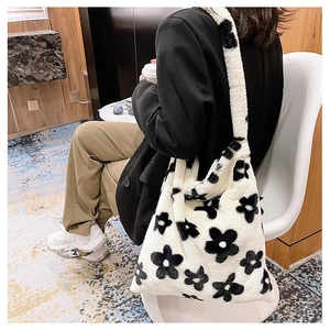 Close-up of fluffy white plush tote bag featuring black floral patterns and soft texture