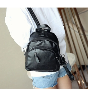 Close-up of black washed leather backpack with dual zippers on a fashion model