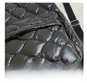 Macro shot of black shiny quilted down fabric with glossy finish and rhombus pattern