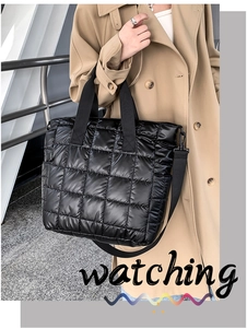 Detail of black quilted tote bag showing padded texture and adjustable strap on a model